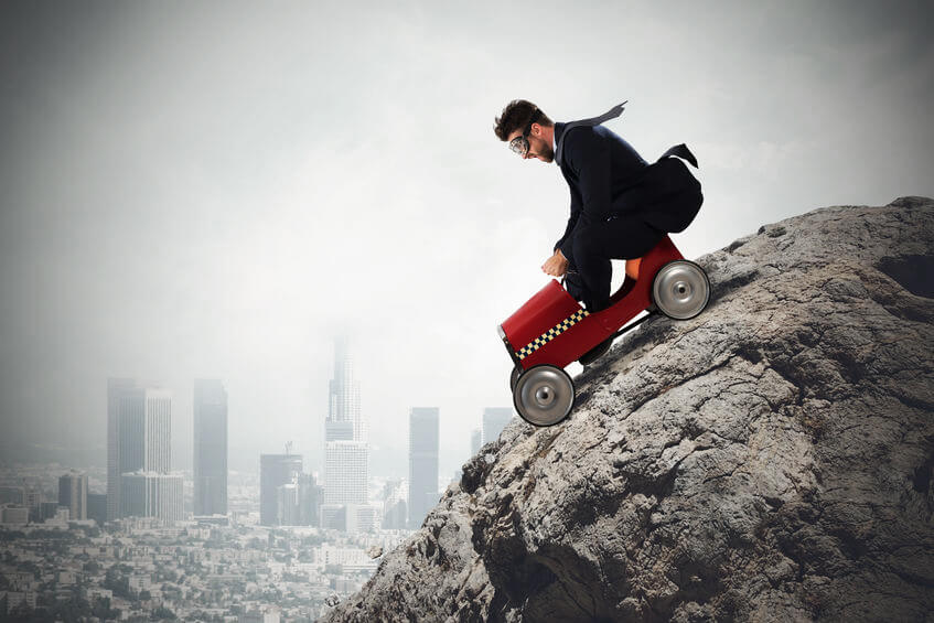 Businessman climb a mountain with a small car. Difficult carrer concept